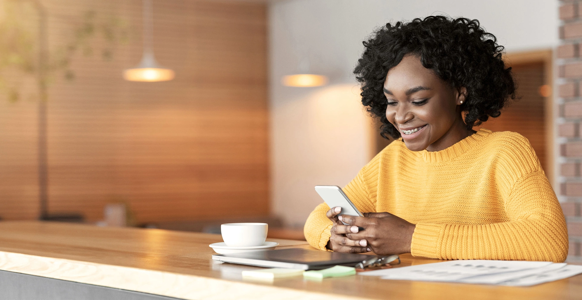 Woman With Braces using Smartphone in a Cafe