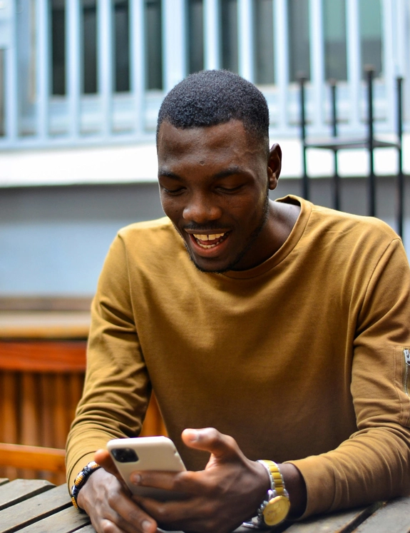 Young Black Man Using Phone In Public
