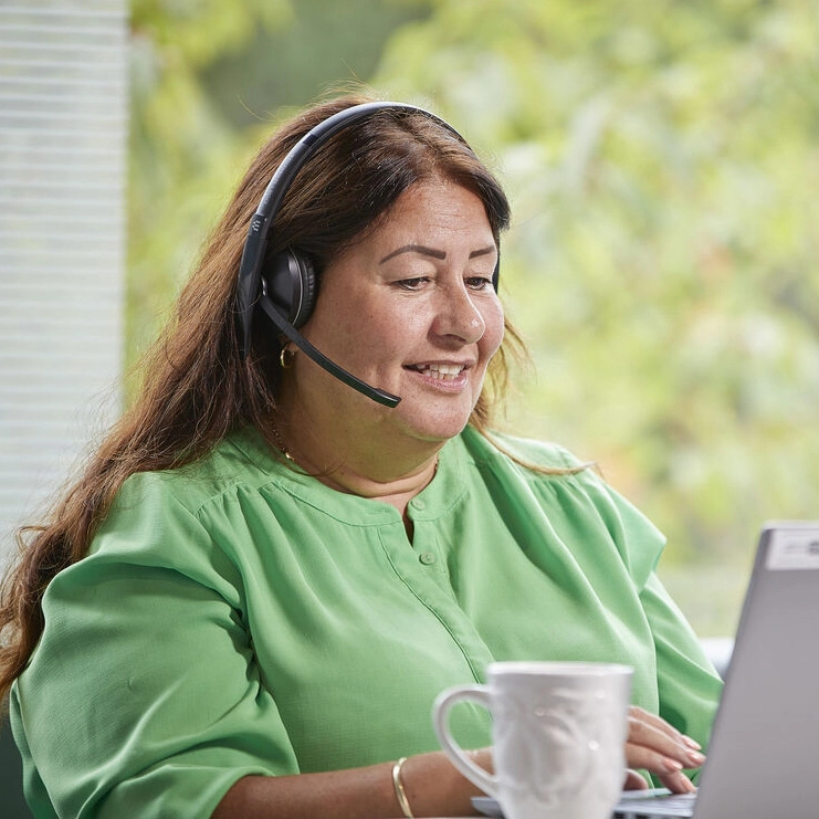 Woman Working From Home with headset and laptop