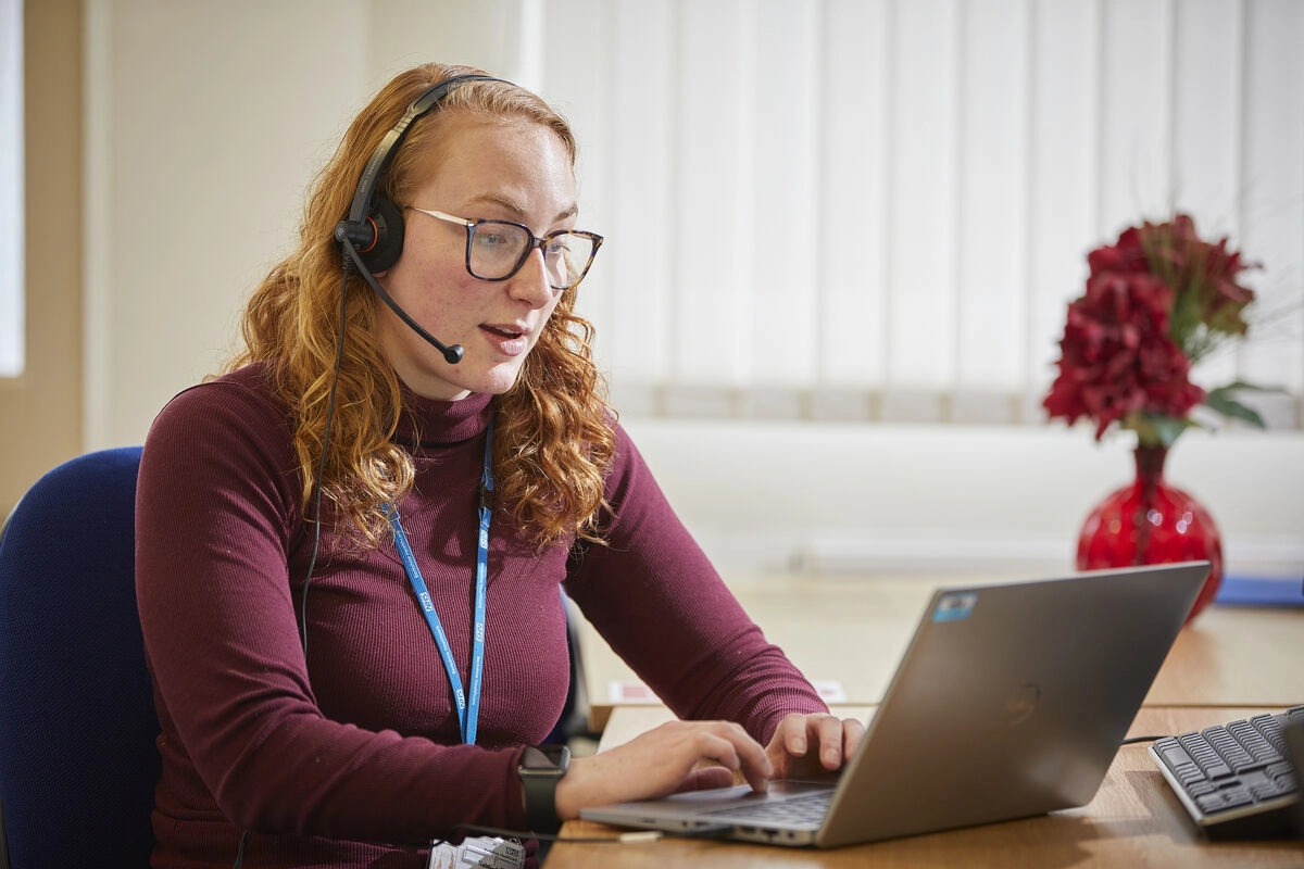 Female Staff Using Laptop And Headset
